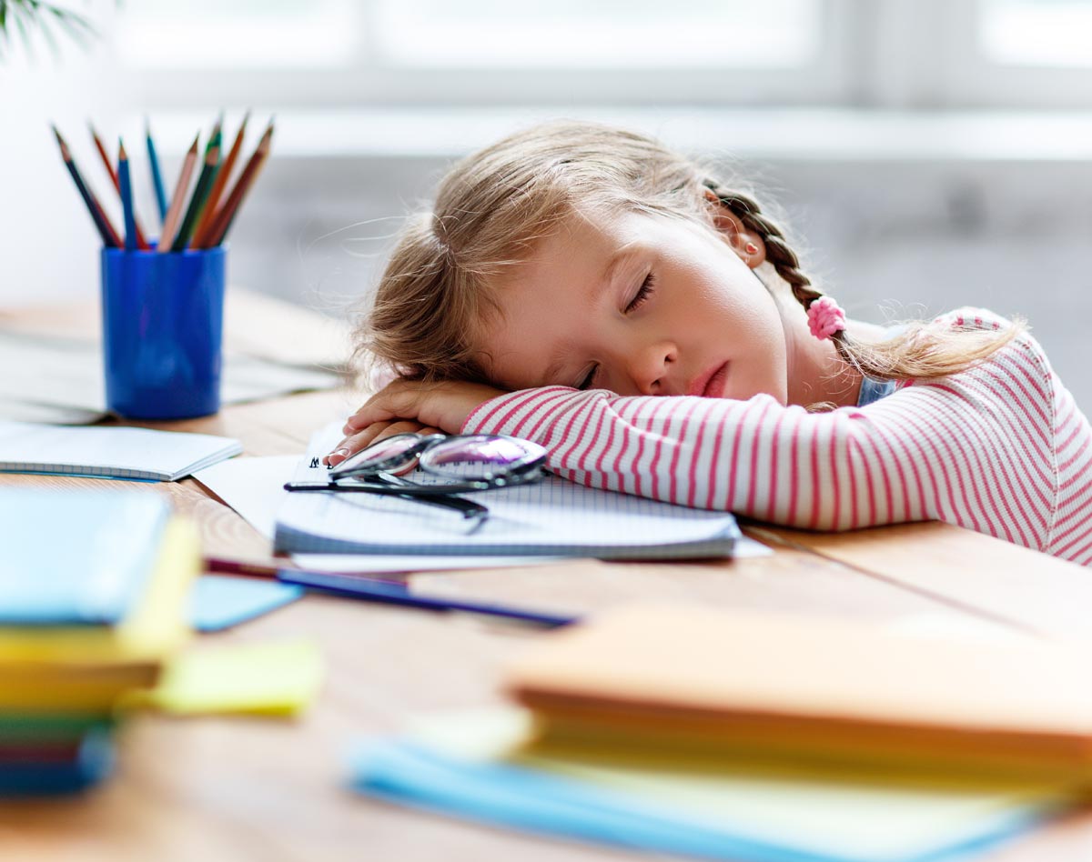 child sleeping at school desk