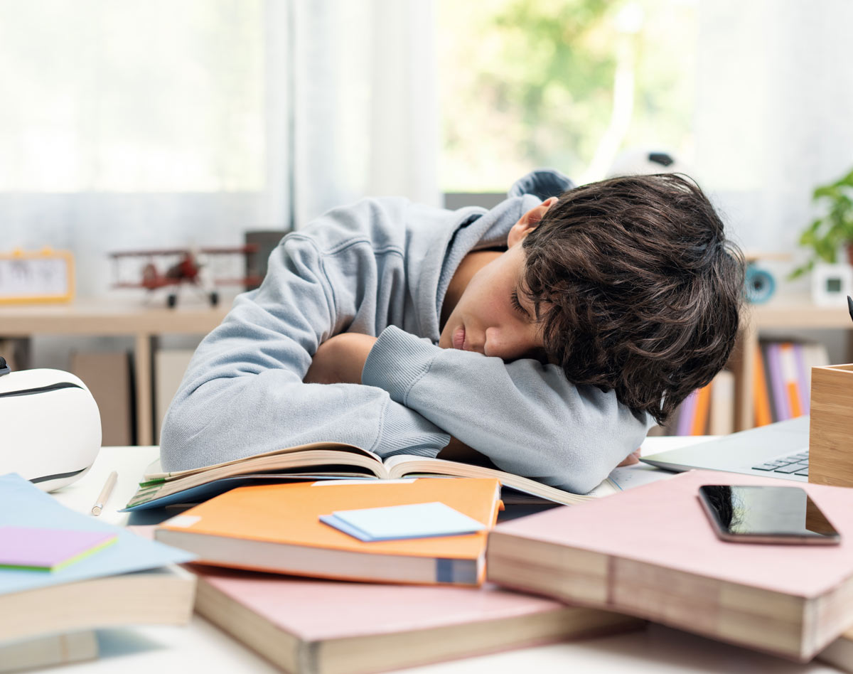 boy sleeping on desk at school