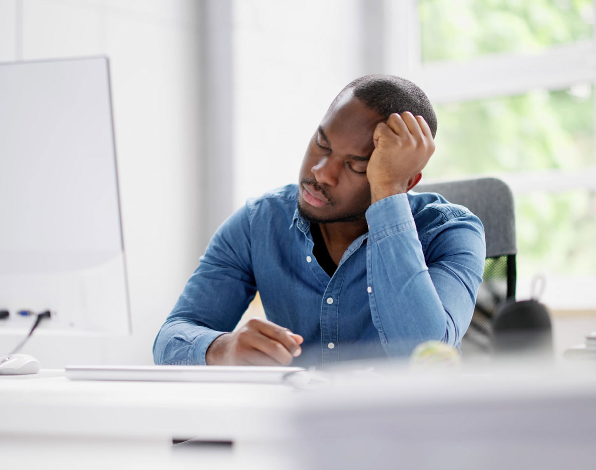 man sleeping in front of computer