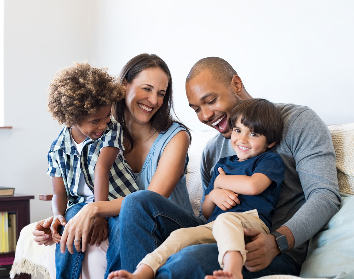 parent and two kids sitting on couch
