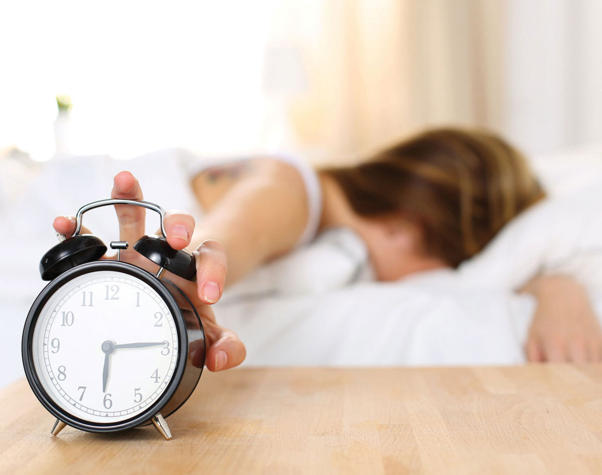 woman stopping alarm clock